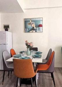 a dining room with a table with chairs and a refrigerator at Amani Grand Luxury Big Suite/Near Airport/3beds in Davao City