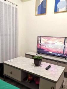 a living room with a table and a tv at Amani Grand Luxury Big Suite/Near Airport/3beds in Davao City +5 photos