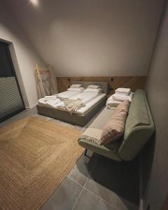 two twin beds in a room with a couch at Trzy Szyszki Maniowy Domki Jezioro Czorsztyńskie Balia oraz Sauna w cenie in Maniowy