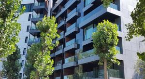 a tall building with trees in front of it at Blue Bike Studio in Mamaia