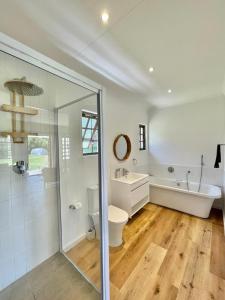 ein Badezimmer mit einer Badewanne, einem WC und einem Waschbecken in der Unterkunft Brummer House - Living The Breede in Malgas
