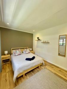 una camera da letto con un grande letto bianco e uno specchio di Brummer House - Living The Breede a Malgas