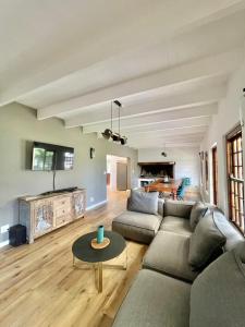 ein Wohnzimmer mit einem Sofa und einem Tisch in der Unterkunft Brummer House - Living The Breede in Malgas