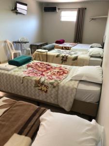 een kamer met vier bedden in een kamer bij Hotel Pousada em frente ao Nações Shopping in Criciúma