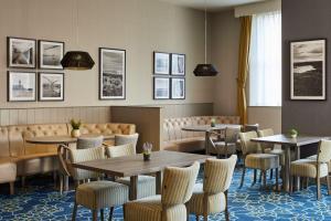a restaurant with tables and chairs and pictures on the wall at Leonardo Hotel Middlesbrough in Middlesbrough