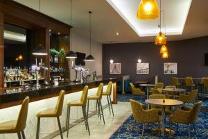 a restaurant with tables and chairs and a bar at Leonardo Hotel Middlesbrough - formerly Jurys Inn in Middlesbrough