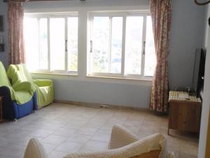 a living room with two chairs and two windows at Traditional apartment in Kalymnos