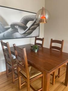 a wooden dining room table with chairs and a painting at Casa del Vika in Halden