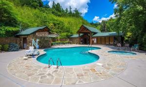 uma piscina em frente a uma casa em Spacious Resort Log Cabin, Easy Drive, Hot Tub, Arcade Gameroom, Mountain Vibe em Gatlinburg