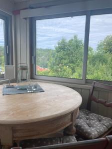 a wooden table in a room with a large window at Casa del Vika in Halden