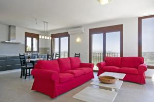 una sala de estar con 2 sillas rojas y una mesa. en Villa Lia - PlusHolidays, en Calpe