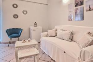 uma sala de estar com um sofá branco e uma cadeira em Casa Ninin - Belcanto Villas em Viareggio