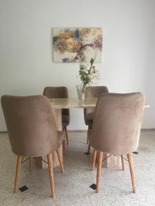 stół jadalny z 3 krzesłami i wazon kwiatów w obiekcie Ideal location in the heart of L’hivernage w Marakeszu
