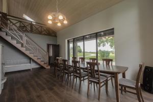 Un comedor con mesa y sillas y una escalera. en Holiday home Uzbazes, en Valmiera