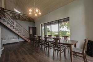 a dining room with a table and chairs and a staircase at Holiday home Uzbazes in Valmiera