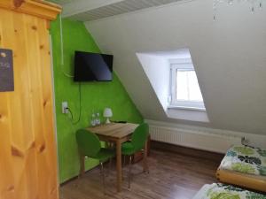 a dining room with a table and a green wall at Rennsteigscheune in Steinbach am Wald