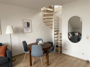 a living room with a table and chairs and a spiral staircase at Ferienwohnung *Harz Raum* in Ballenstedt