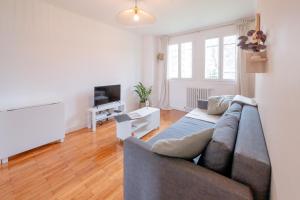 a living room with a couch and a television at BonaBonheur - T3Bis - Havre de Paix Toulousain in Toulouse
