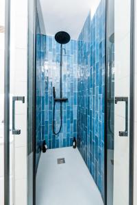 a bathroom with a shower with blue tiles at BonaBonheur in Toulouse