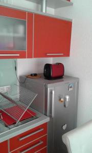 a kitchen with red cabinets and a stainless steel refrigerator at Bjelasnica Mini Studio in Sarajevo