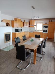 a kitchen with a wooden table and black chairs at Ferienwohnung Ortner in Sankt Johann in Tirol