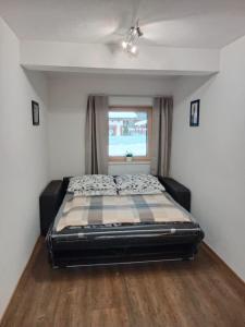 a bed in a room with a window at Ferienwohnung Ortner in Sankt Johann in Tirol