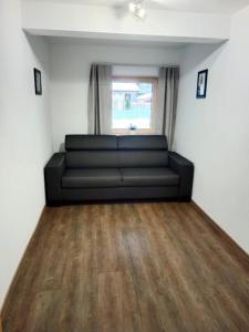 a living room with a black couch and a window at Ferienwohnung Ortner in Sankt Johann in Tirol