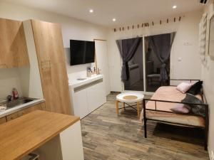 cocina pequeña y sala de estar con cama y mesa en Appartement au cœur des Albères, en Le Boulou