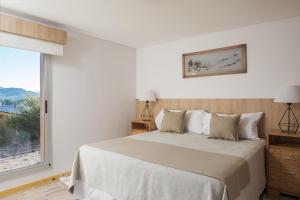 um quarto branco com uma cama e uma janela em Bahía Montaña Resort em Villa La Angostura