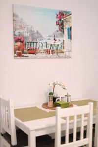 un tavolo e sedie con un dipinto sul muro di Flower Apartment a Jáchymov