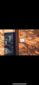 曼徹斯特的住宿－Lovely 1 bed apartment in Salford，前面有一扇门的砖砌建筑