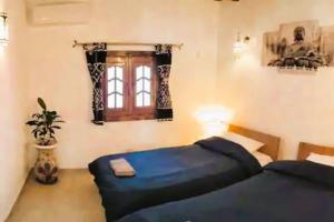 a bedroom with two beds and a window at Shanti Garden House in Dahab