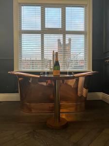 a bath tub with a bottle of wine sitting on it at Eastgate Rows Apartments in Chester