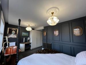 a bedroom with blue walls and a bed and lights at Eastgate Rows Apartments in Chester