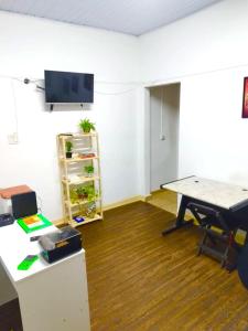 an office with a table and a tv on a wall at Casa da Vila Hostel Guest House in São Paulo