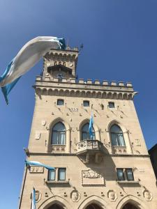 un bâtiment avec une tour d'horloge devant lui dans l'établissement La Famosa Dimora Ambasciatore, à Saint-Marin