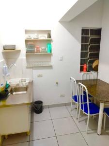 a kitchen with a table and chairs in a kitchen at Casa da Vila Hostel Guest House in São Paulo