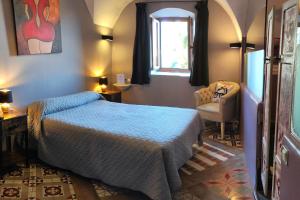 een slaapkamer met een bed, een stoel en een raam bij Hotel la Boheme in Cáceres