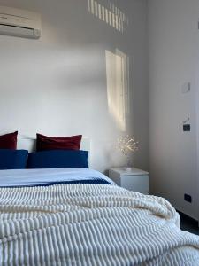 a bedroom with a white bed with a blue comforter at *Love'n fly apartament * Airport- Ducati in Bologna