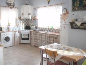 a kitchen with a table and a white refrigerator at Traditional apartment in Kalymnos