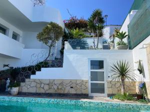a white house with a swimming pool and stairs at Villa Oasis La Paz - Romen Studio - ADULTS ONLY in Puerto de la Cruz