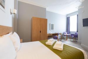 Una habitación de hotel con una cama con dos toallas. en The Burlington Hotel, en Eastbourne