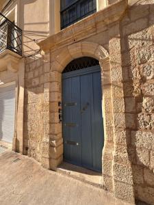 una porta blu del garage in un edificio in pietra di Valletta Dome Apartment a La Valletta