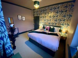 Un dormitorio con una cama grande y una pared en LFC 6 Bedroomed House sleeps 14, en Liverpool