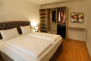 a bedroom with a large bed and a closet at Boardinghotel Westarkaden Suites in Heidelberg