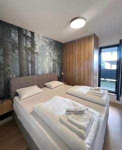 a bedroom with two beds with towels on them at Arbor Apartment in Bjelašnica +5 photos