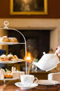 a person pouring tea from a tea pot into a cup at Ard na Sidhe Country House Hotel in Killorglin