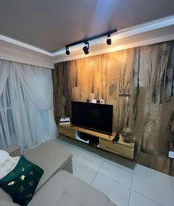 a living room with a flat screen tv on a wall at aconchegante apt de 1 dormitorio in Rio de Janeiro