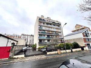 Le P'tit Montreuillois - Appartement proche Paris في مونتروي: مبنى طويل على شارع المدينة وبه مباني