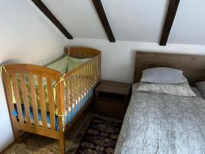 a small bedroom with a crib and a bed at Vacation House Studenac in Bihać